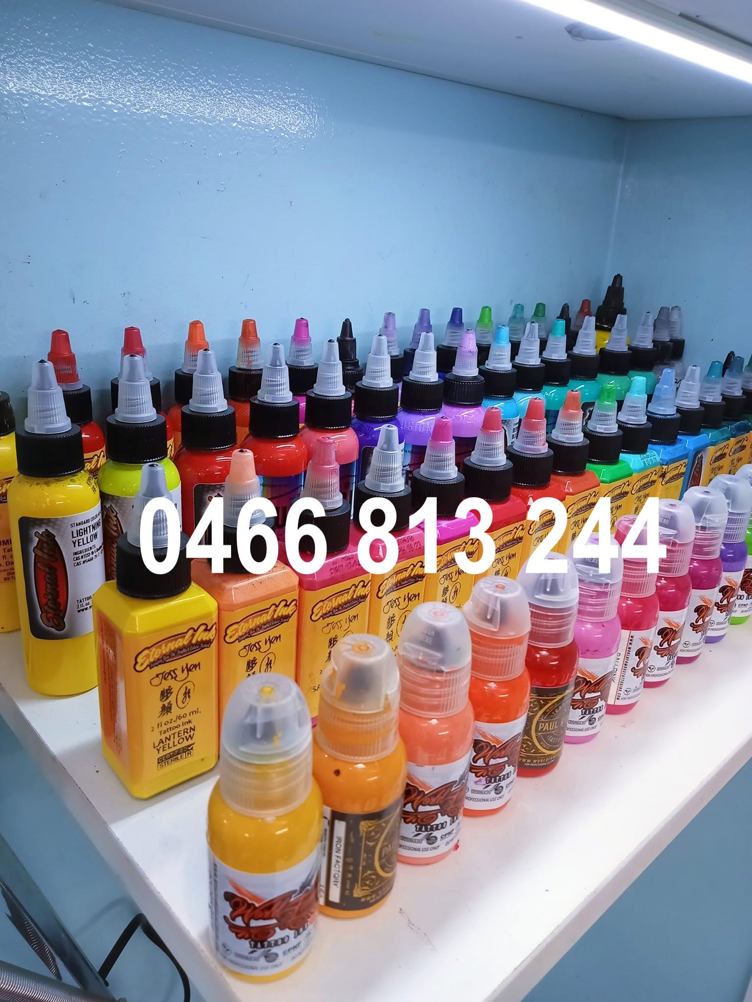 A shelf of tattoo ink bottles in every colour at the studio